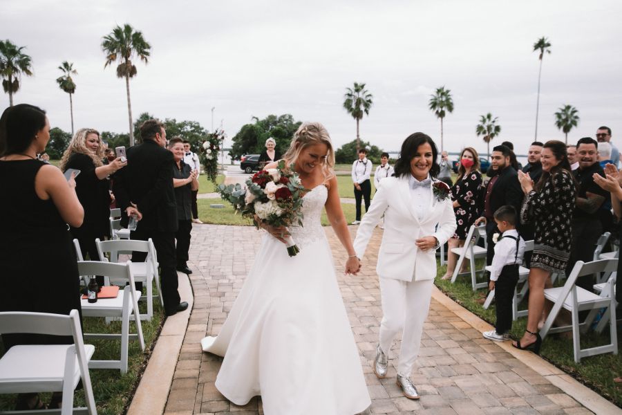 A bride and groom walking down a brick path of Fenway Hotel