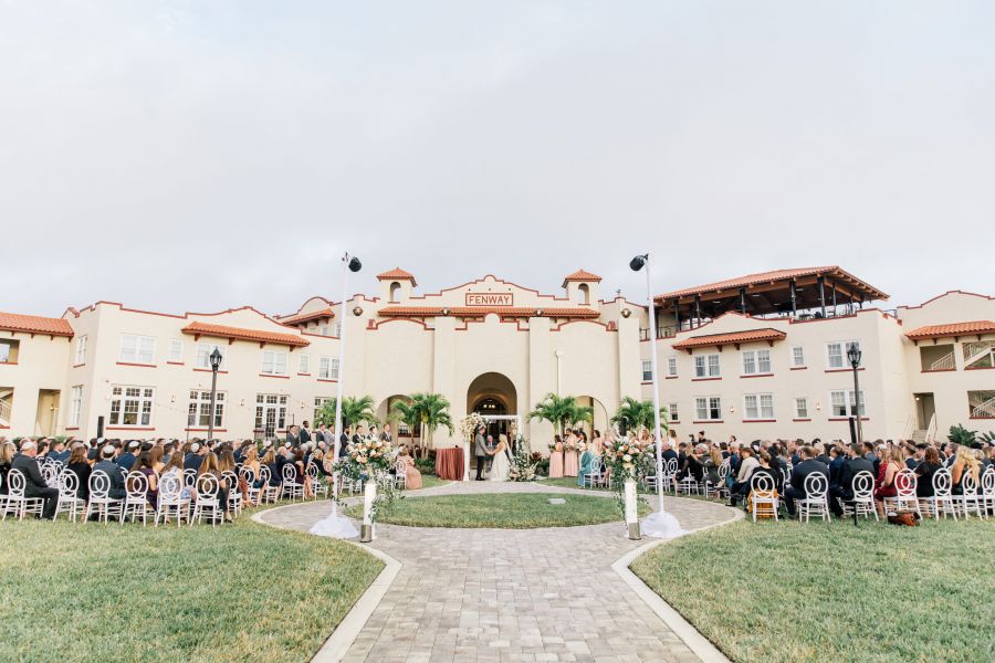 A group of people outside of Fenway Hotel attending a wedding ceremony