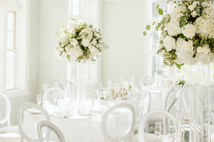 A white room with white chairs and white tablecloths