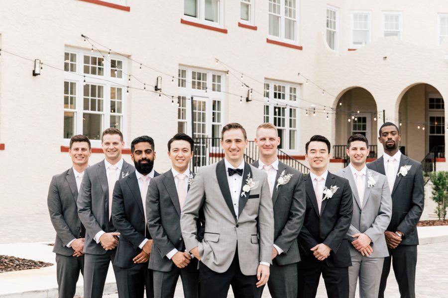 A group of men in suits standing on the patio at Fenway Hotel