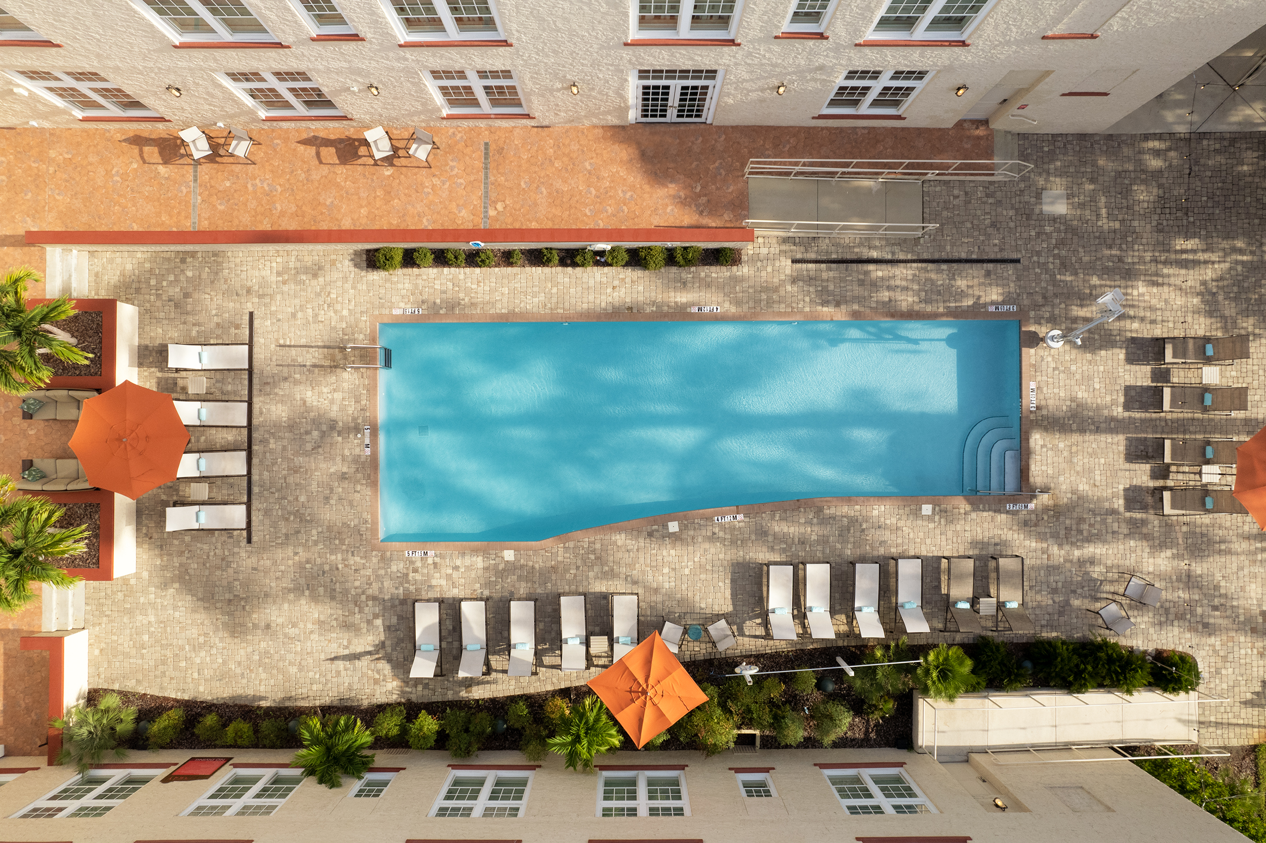 A pool and lounge chairs in a courtyard