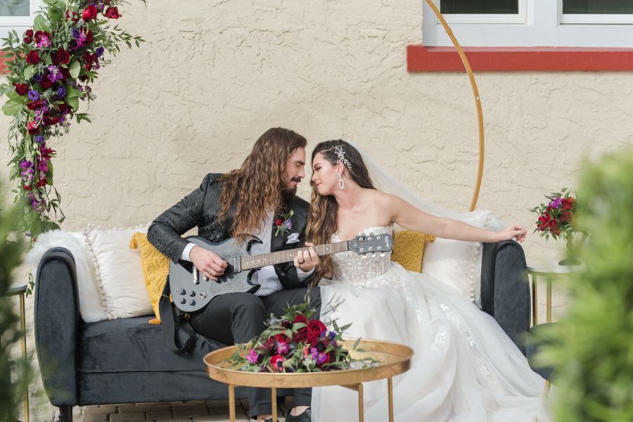 A person and person sitting on a couch with a guitar